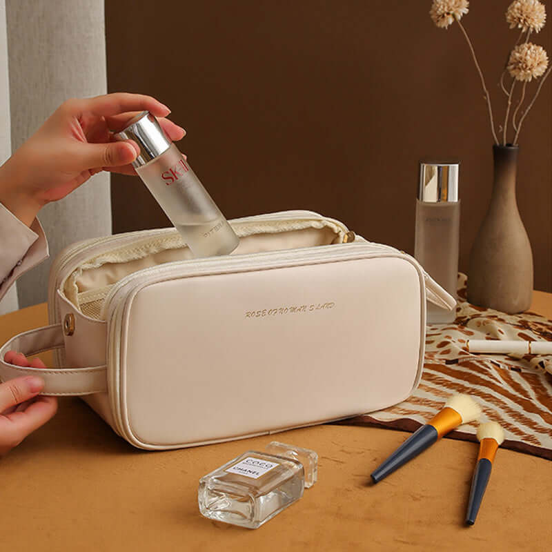 Double zipper cosmetic bag in beige, stylishly holding skincare products on a vanity surface.