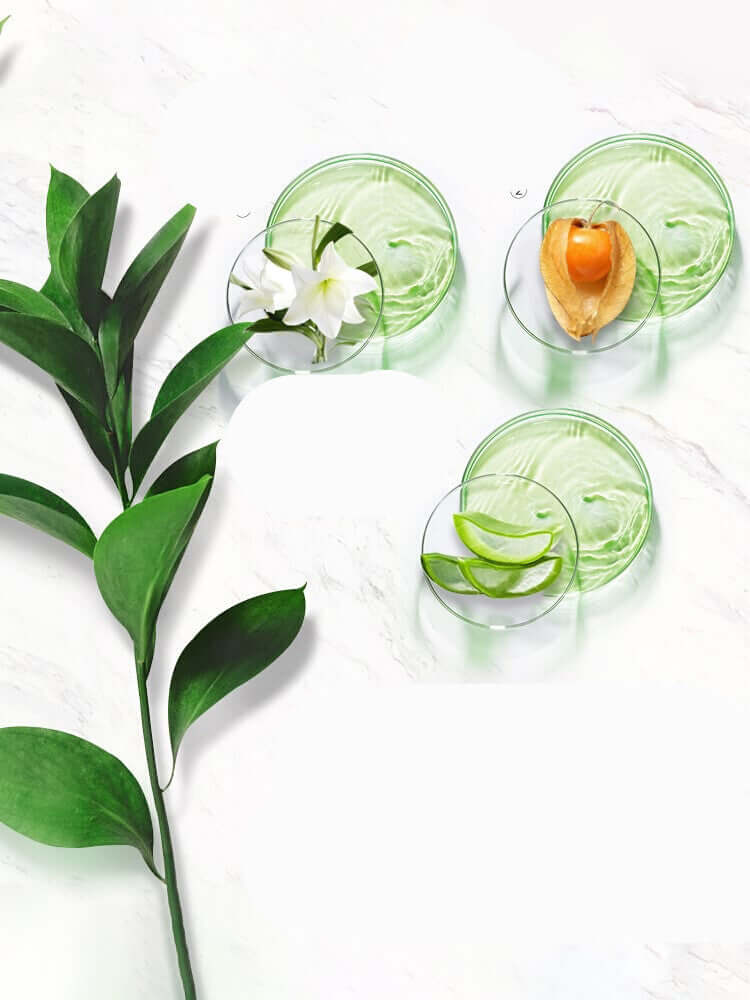 Natural summer skincare products with green textures, fresh ingredients, and botanical elements on a marble background.