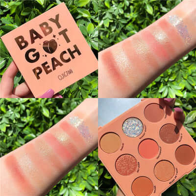 Swatches of the Baby Got Peach eyeshadow palette showcasing vibrant colors on skin against a leafy background.