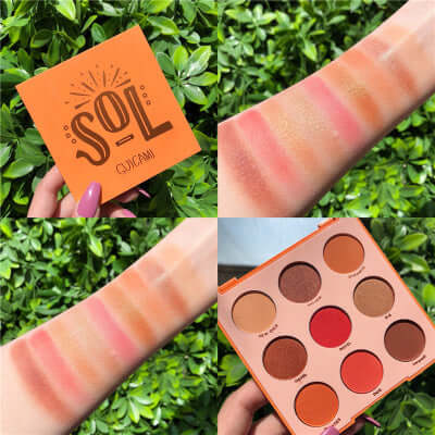 Swatches of the Sol eyeshadow palette on arm, showcasing colorful shades and packaging against green foliage.