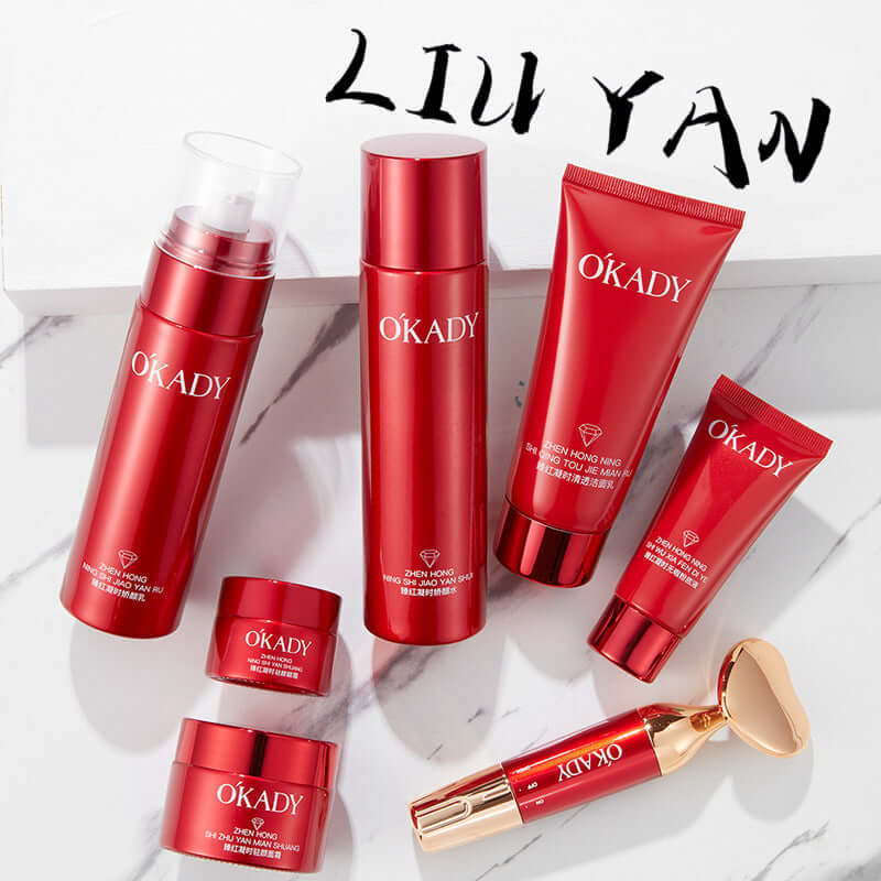 High-end skin care products set with red packaging, featuring cleansers, creams, and a facial roller.